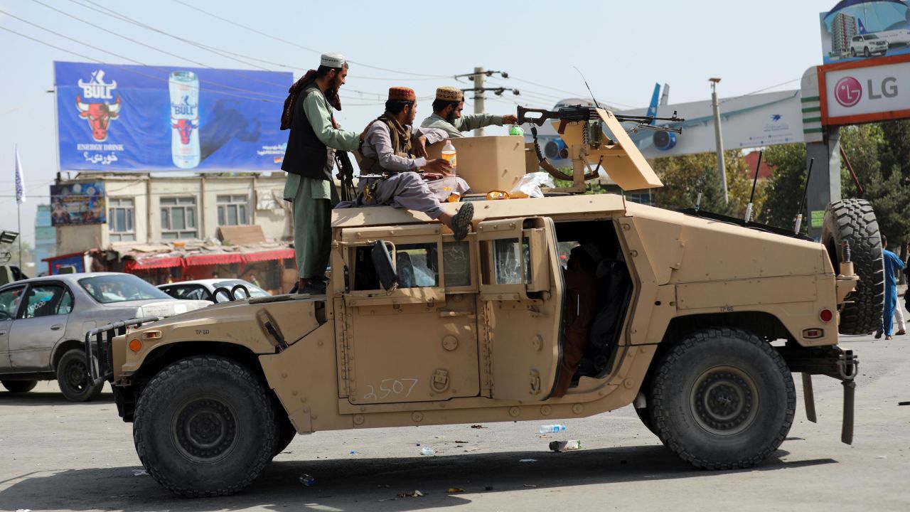 Taliban fighters stand guard in front of the Hamid Karzai International Airport, in Kabul, Afghanistan, Monday, Aug. 16, 2021.