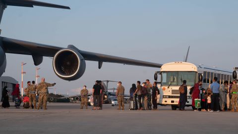 A group of Afghan evacuees depart a C-17 Globemaster III aircraft at Ramstein Air Base, Germany.