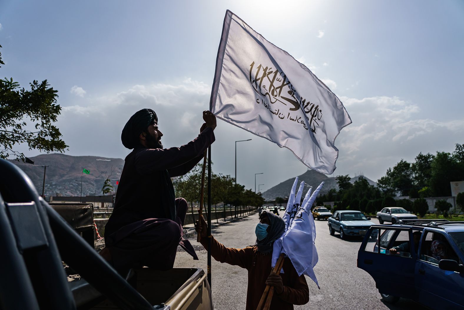 A boy sells Taliban flags to put on vehicles in the middle of a Kabul intersection on August 20.