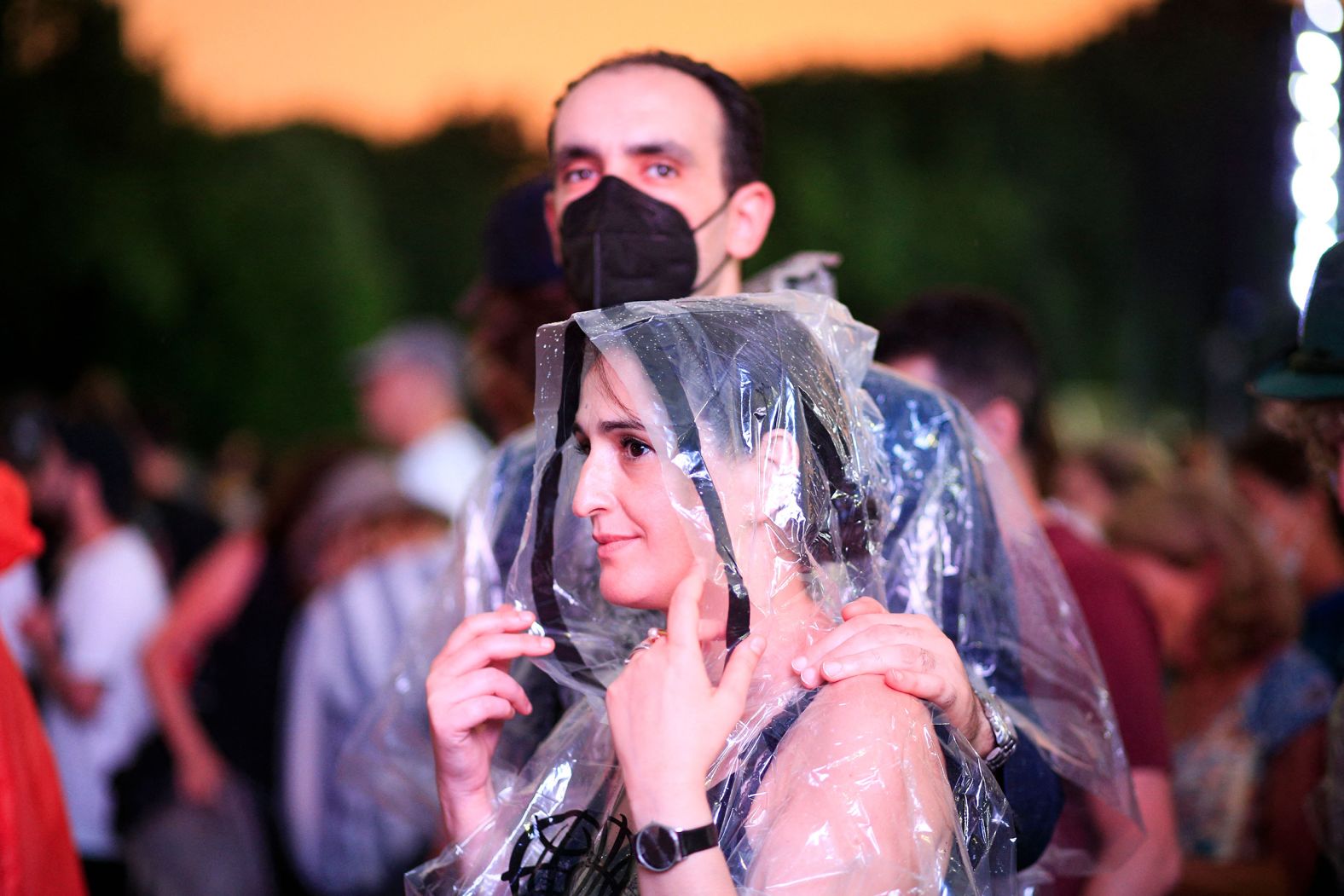 Audience members begin to leave and take shelter from the weather. 