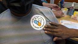 A healthcare worker puts a sticker on a resident that read in Spanish  "I got vaccinated against Covid-19" after receiving a dose of the Pfizer-BioNTech Covid-19 vaccine at a vaccination site in Lake Worth, Florida, U.S., on Friday, Aug. 13, 2021. Florida's weekly Covid-19 cases rose to a record, with confirmed infections increasing 12% to 151,415 for the seven days through Thursday as Governor Ron DeSantis stakes his claim against mask mandates. Photographer: Saul Martinez/Bloomberg via Getty Images
