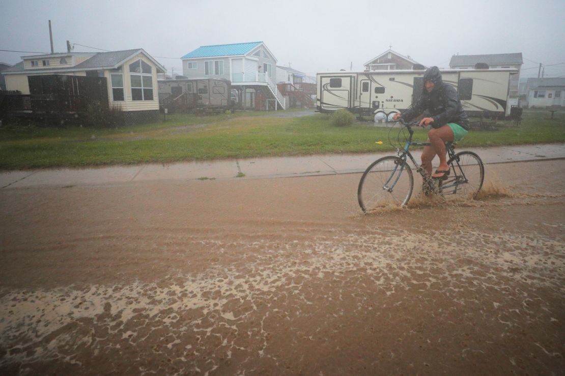 A bicyclist rides through a flooded street as Tropical Storm Henri approaches South Kingstown, Rhode Island, on Sunday, August 22.