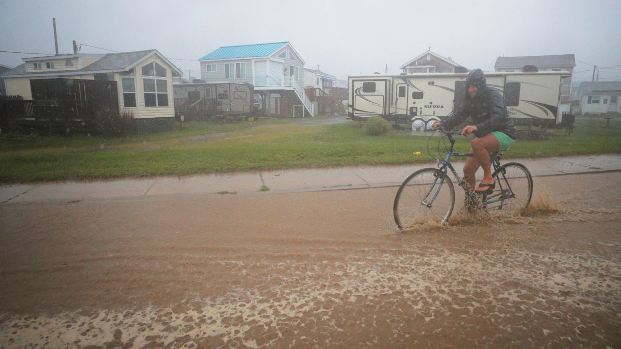 A bicyclist rides through a flooded street as Tropical Storm Henri approaches South Kingstown, Rhode Island, on Sunday, August 22.