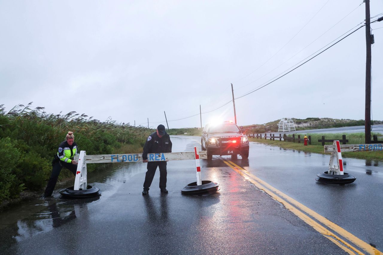 Sgt. Jim Cavanagh and officer Danielle McManus of the Southampton Town Police Department close a flooded road on Long Island, New York, on August 22.