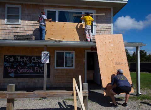 Men work on covering the windows at Salty's Clam Shack as Henri approached Westerly, Rhode Island, on August 21.