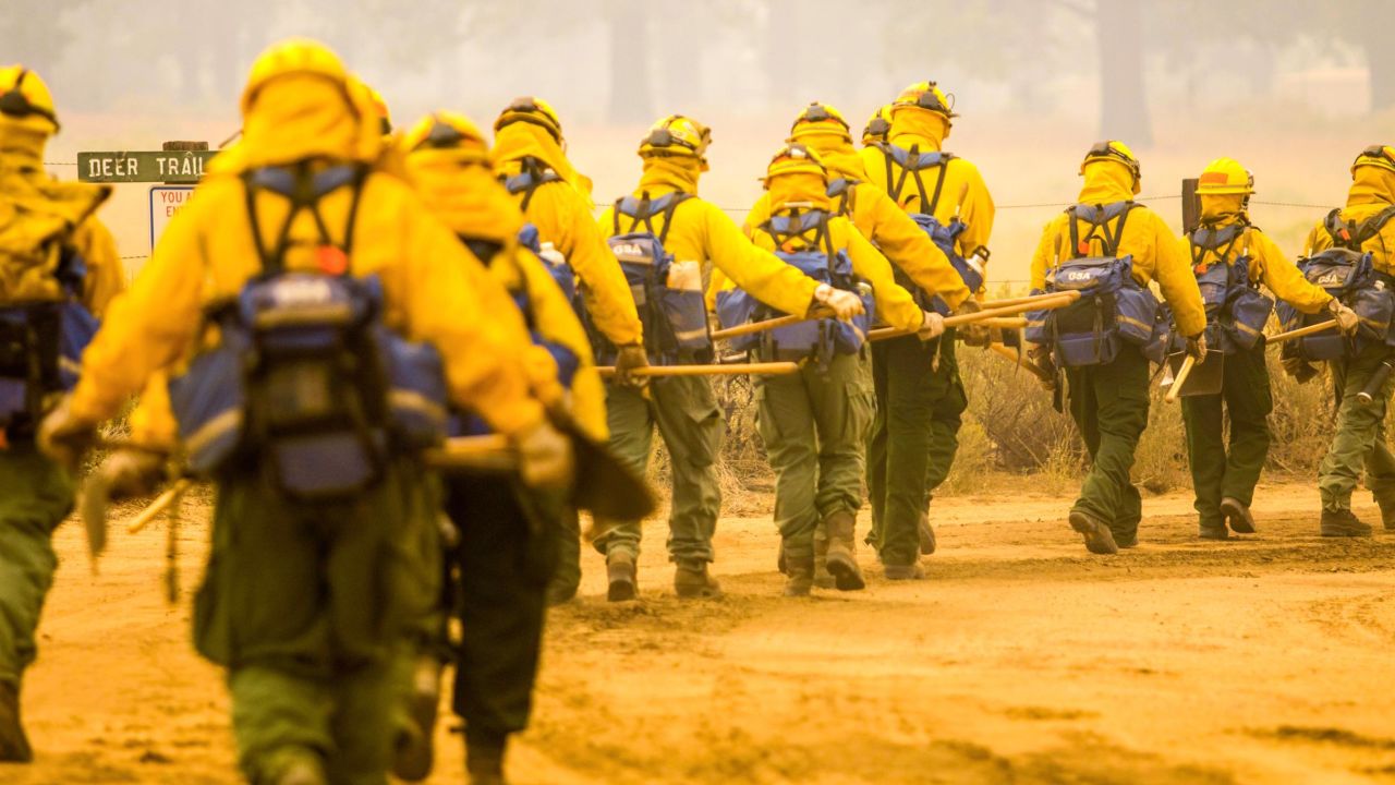 Firefighting hand crews walk towards the fire line of the Dixie Fire on August 21.