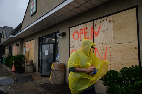A man walks outside a boarded-up convenience store in Montauk, New York, on August 22.