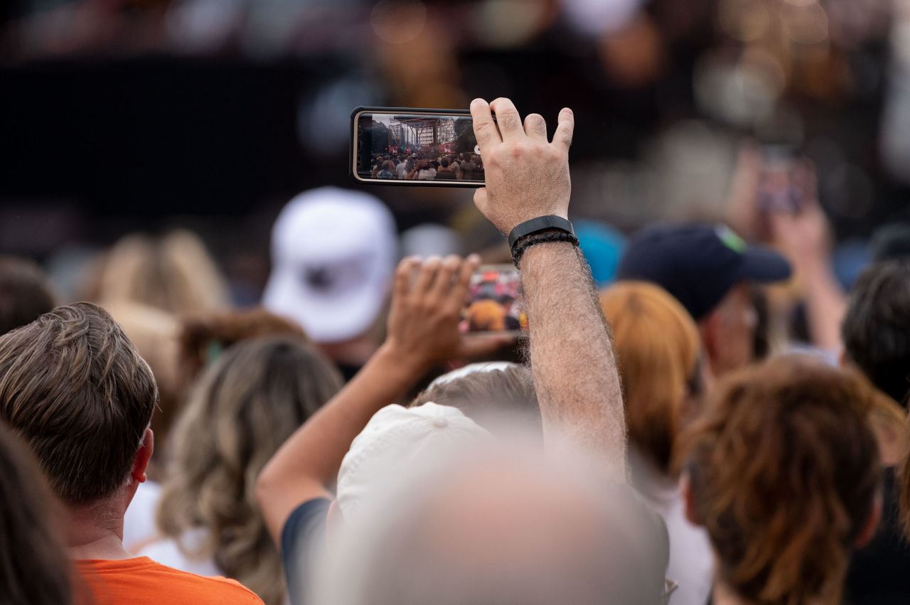 A member of the audience uses a phone to capture the moment. 