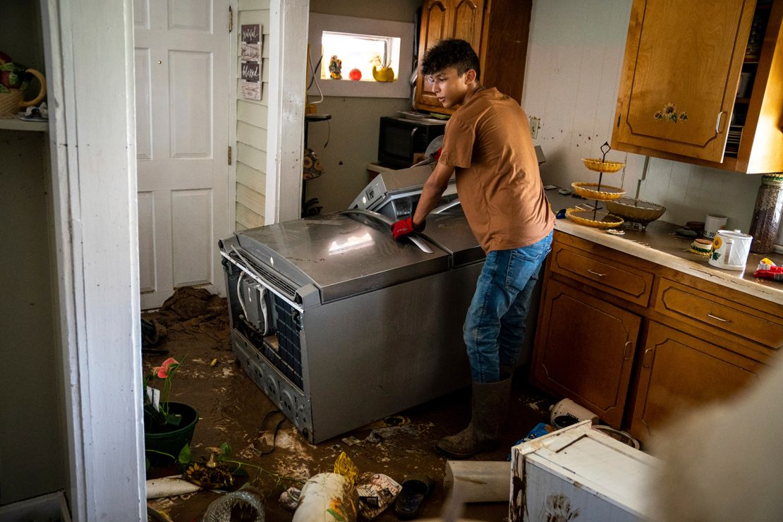 Kalyn Clayton, 16, surveys the damaged kitchen of a home while volunteering with his church youth group in Waverly, Tennessee.