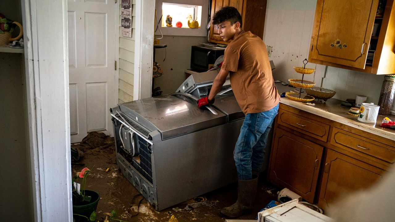 Kalyn Clayton, 16, surveys the damaged kitchen of a home while volunteering with his church youth group in Waverly, Tennessee.