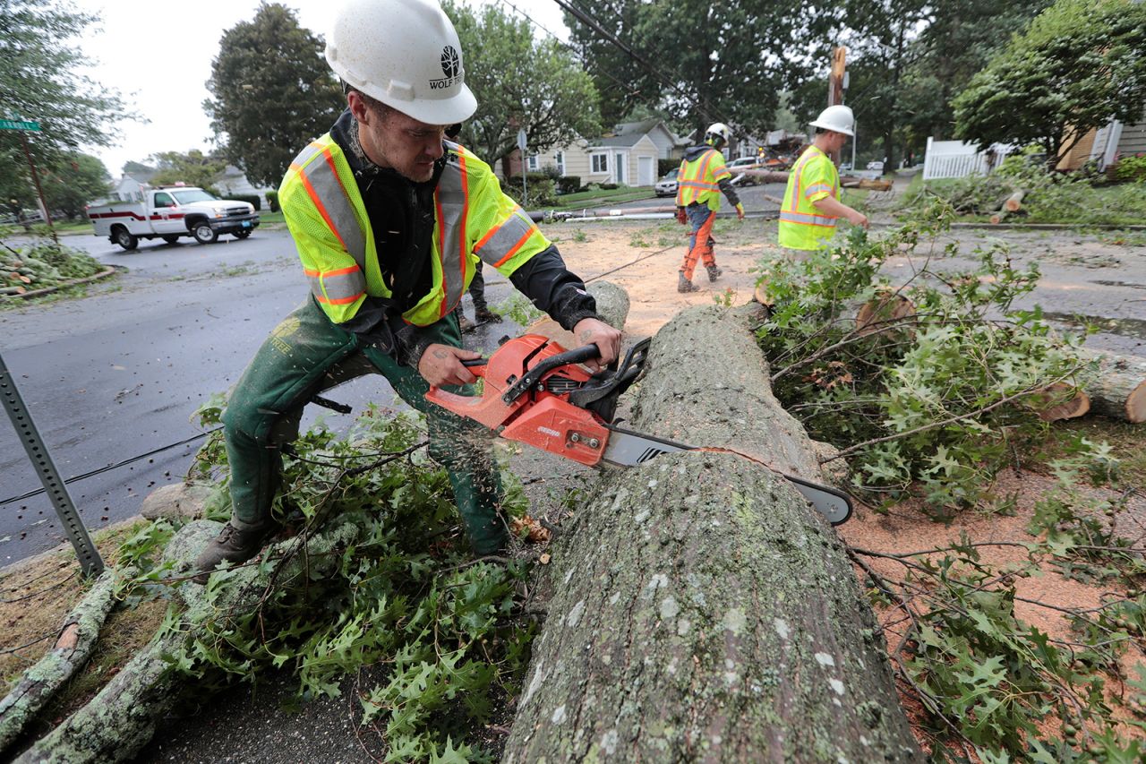 Ryan Bachus, who drove 17 hours from Tennessee with his colleagues to offer assistance, cuts down a tree that fell in New Bedford, Massachusetts.