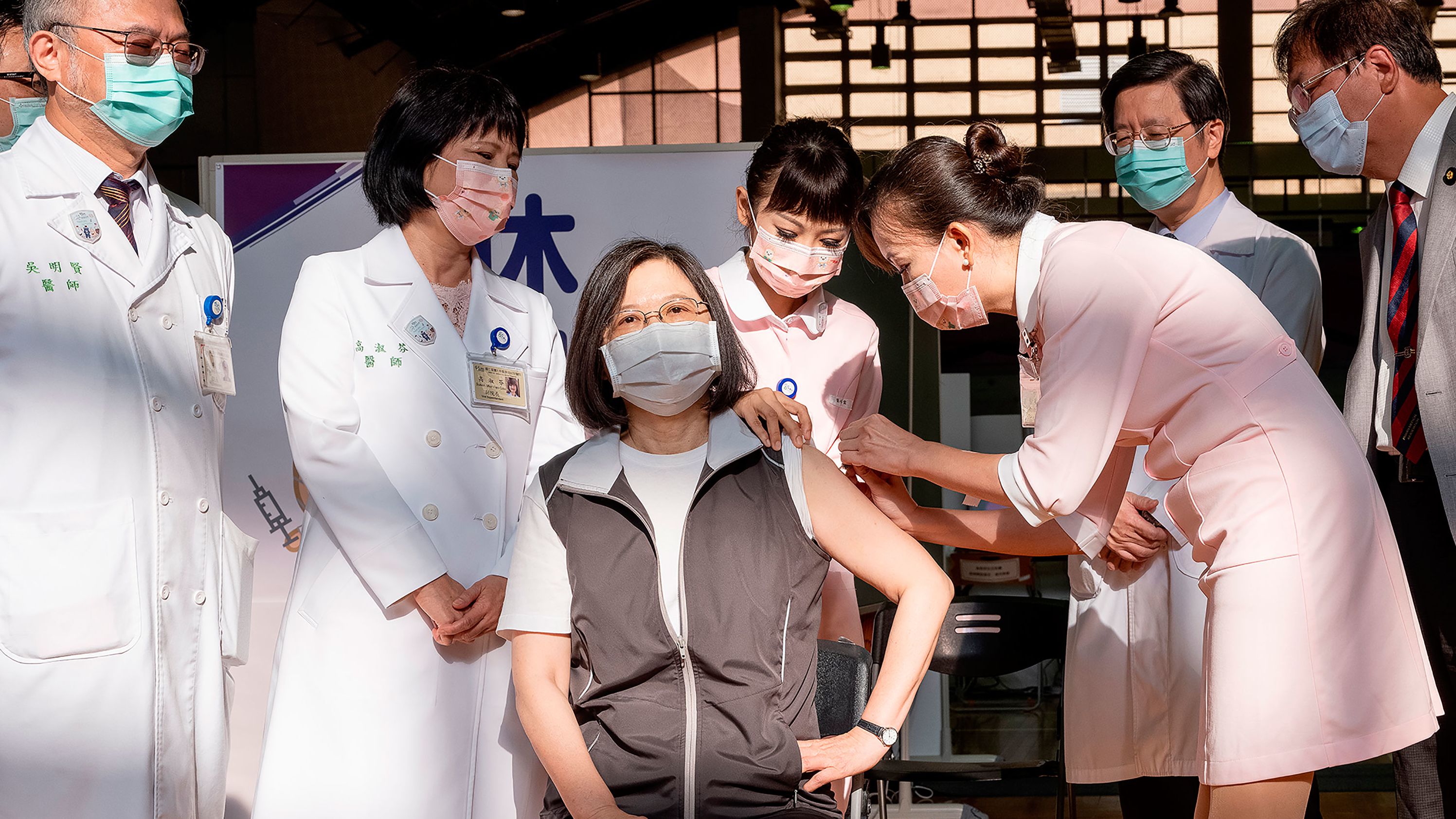 Taiwanese President Tsai Ing-wen, center, receives her first shot of the island's first domestically developed coronavirus vaccine at the Taiwan University Hospital in Taipei, Taiwan on Monday, August 23.