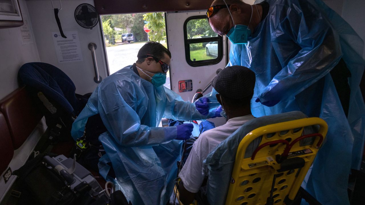 Medics from the Houston Fire Department EMS prepare to transport a man with possible Covid-19 symptoms to a hospital on August 16.