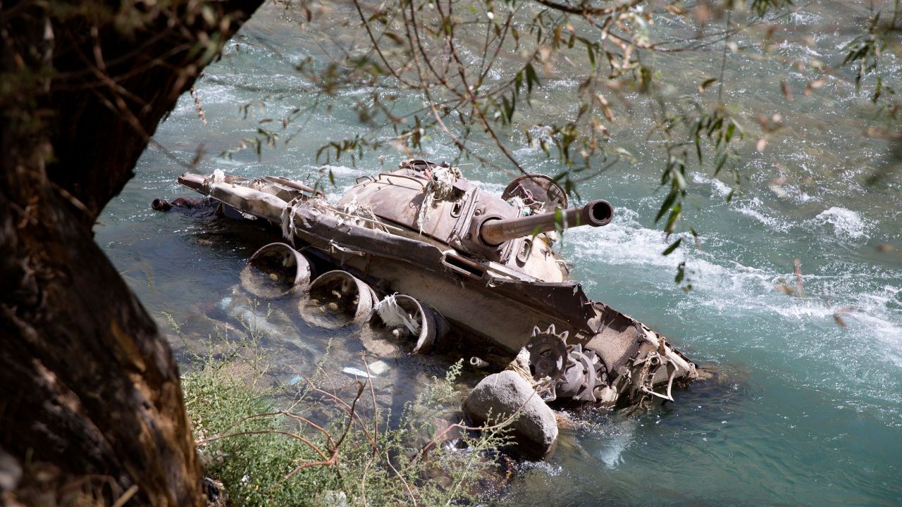 A destroyed Soviet-era tank lies in the Panjshir River in 2016 in Bazarak, Afghanistan. 