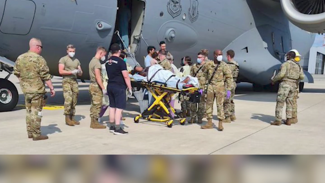 Medical support personnel help an Afghan mother, whose identity has been digitally obscured at source, with her family off a US Air Force C-17 transport aircraft moments after she delivered a child aboard the aircraft upon landing at Ramstein Air Base, Germany, on Saturday.