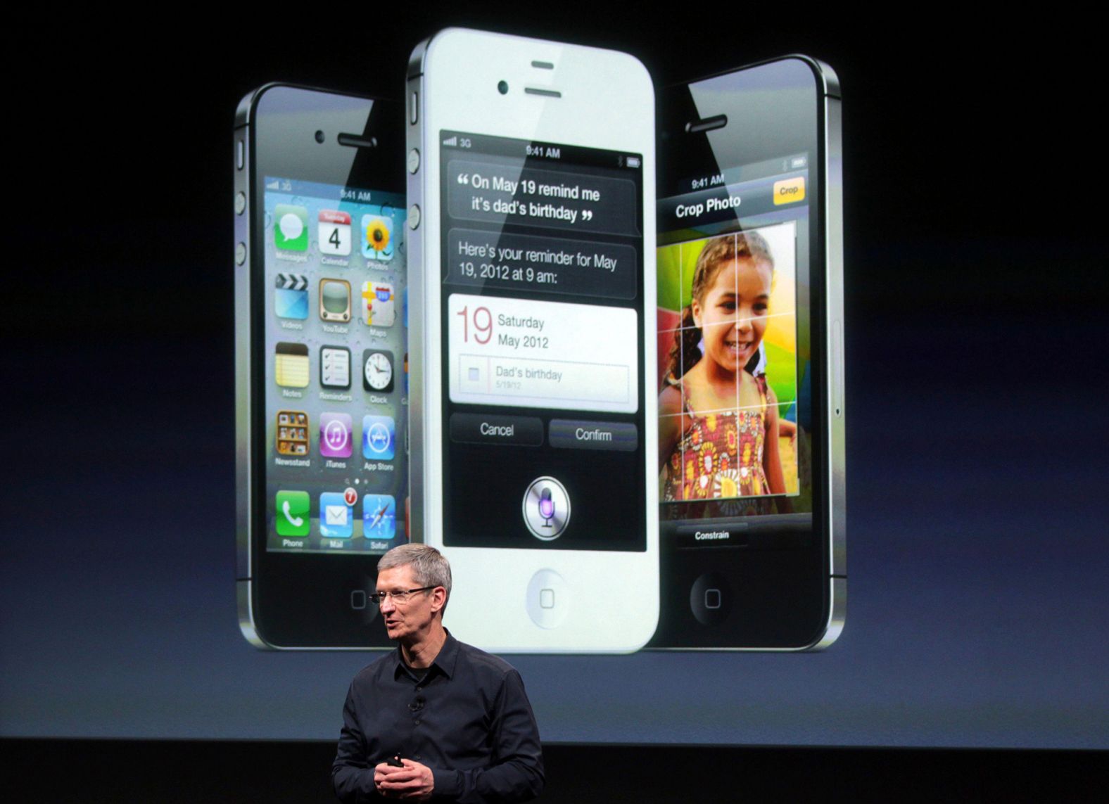 Cook speaks in front of an image of an iPhone 4S at Apple headquarters in 2011. 
