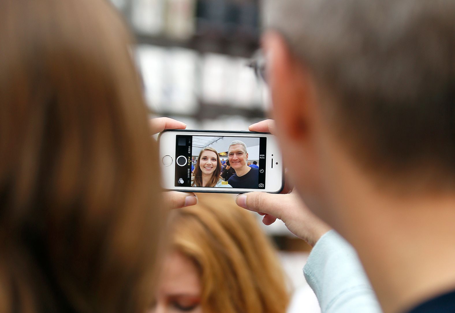 Cook takes a photo with an Apple employee during the launch of the iPhone 6 at an Apple store in Palo Alto, California, in September 2014.