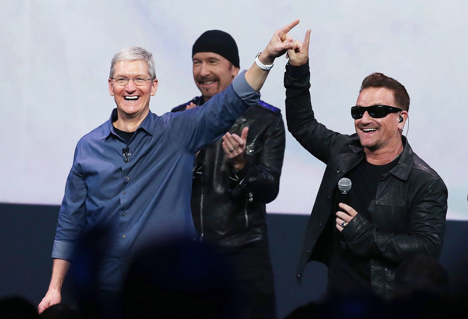 Cook greets the crowd with U2 singer Bono as U2 guitarist The Edge looks on during an Apple special event at the Flint Center for the Performing Arts in Cupertino in September 2014.