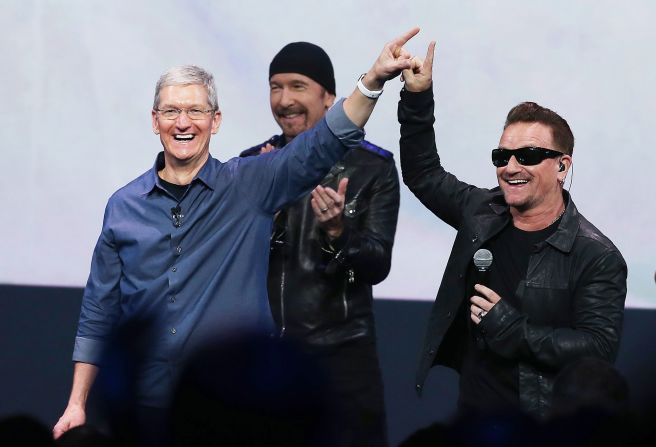 Cook greets the crowd with U2 singer Bono as U2 guitarist The Edge looks on during an Apple special event at the Flint Center for the Performing Arts in Cupertino in September 2014.