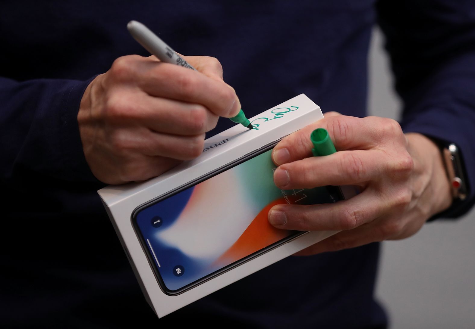 Tim Cook signs the box of a new iPhone X at an Apple Store in Palo Alto in November 2017. The highly anticipated iPhone X went on sale around the world that day. 