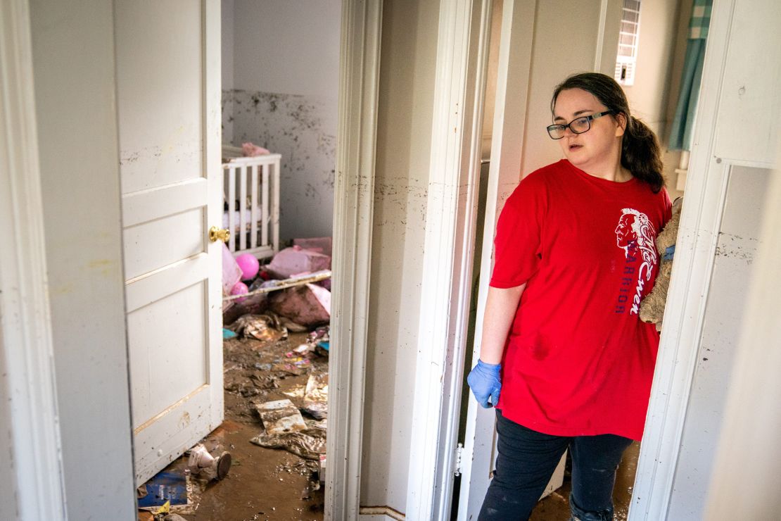 Vanessa Yates checks the damage inside her home in Waverly following the flood.