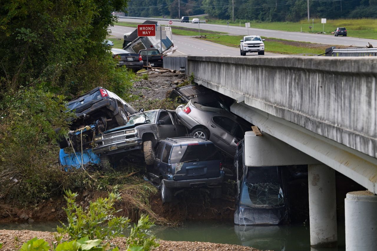 Cars that were swept up in floodwaters sit on the banks of Waverly's Blue Creek on Monday, August 23.