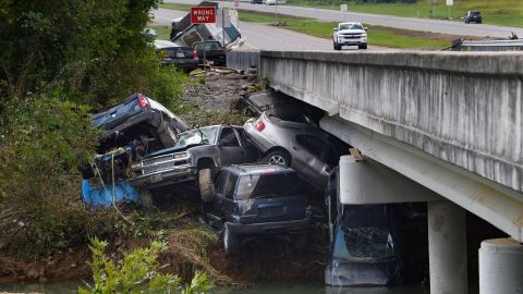 Cars that were swept up in floodwaters sit on the banks of Waverly's Blue Creek on Monday, August 23.
