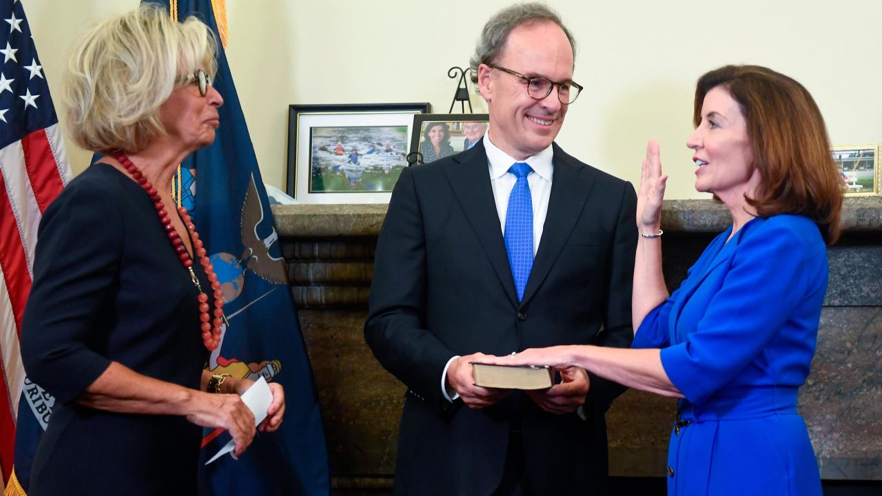 Kathy Hochul, right, is sworn in as New York state's governor by Court of Appeals Chief Judge Janet DiFiore on a Bible held by her husband Bill Hochul. 
