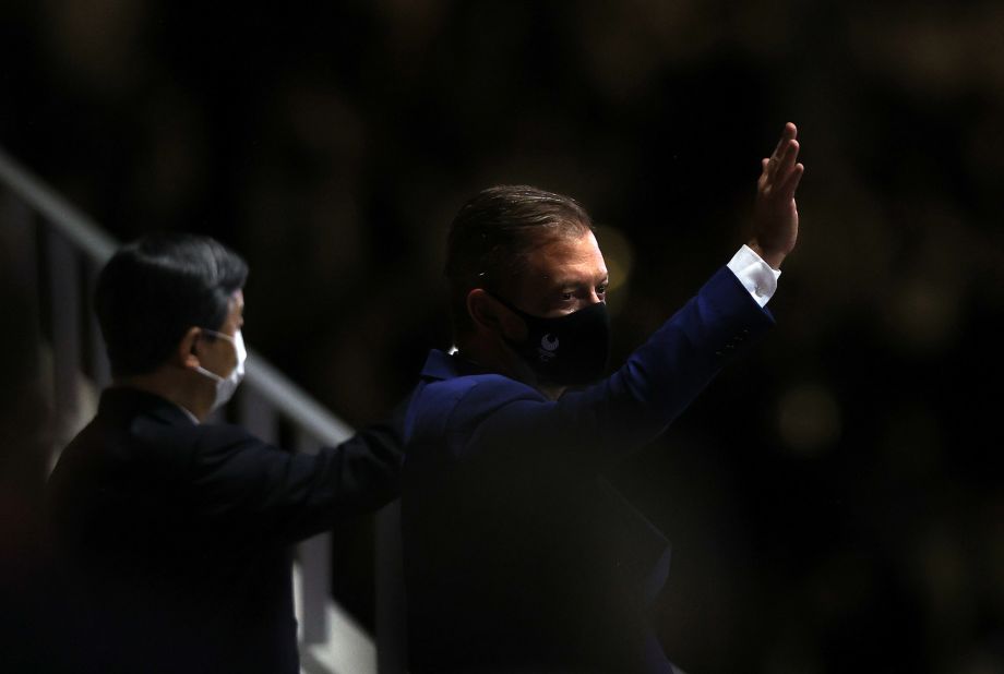 International Paralympic Committee President Andrew Parsons waves after arriving for the opening ceremony. On the left is Japan's Emperor Naruhito.