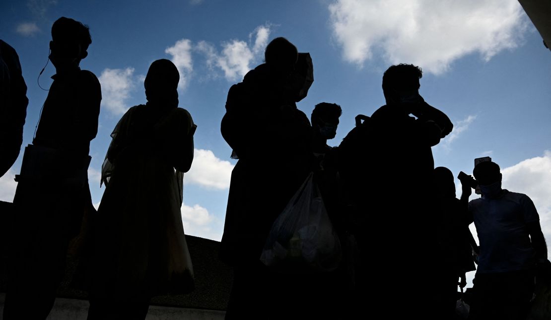 Refugees from Afghanistan wait to board a bus after arriving and being processed at Dulles International Airport in Dulles, Virginia on August 23, 2021. Around 16,000 people were evacuated over the past 24 hours from Afghanistan through the Kabul airport, the Pentagon said on August 23, 2021, as the US speeds toward completing its airlift by an August 31 deadline. 