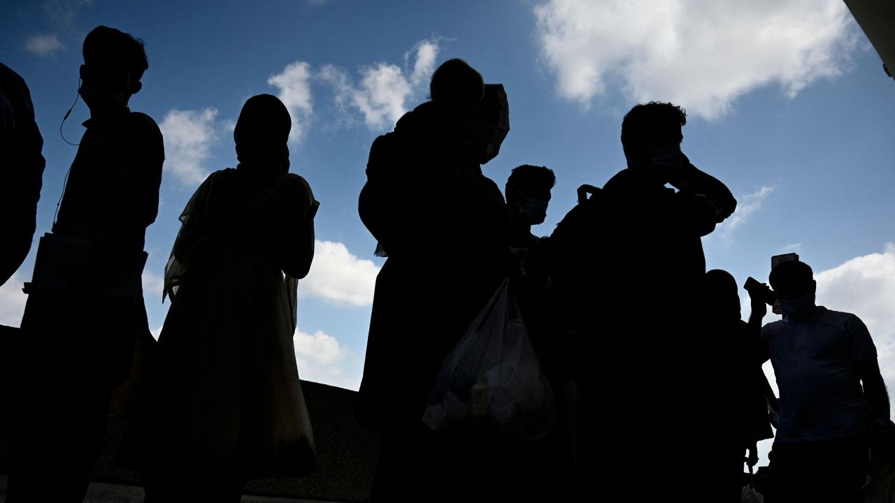 Refugees from Afghanistan wait to board a bus after arriving and being processed at Dulles International Airport in Dulles, Virginia.