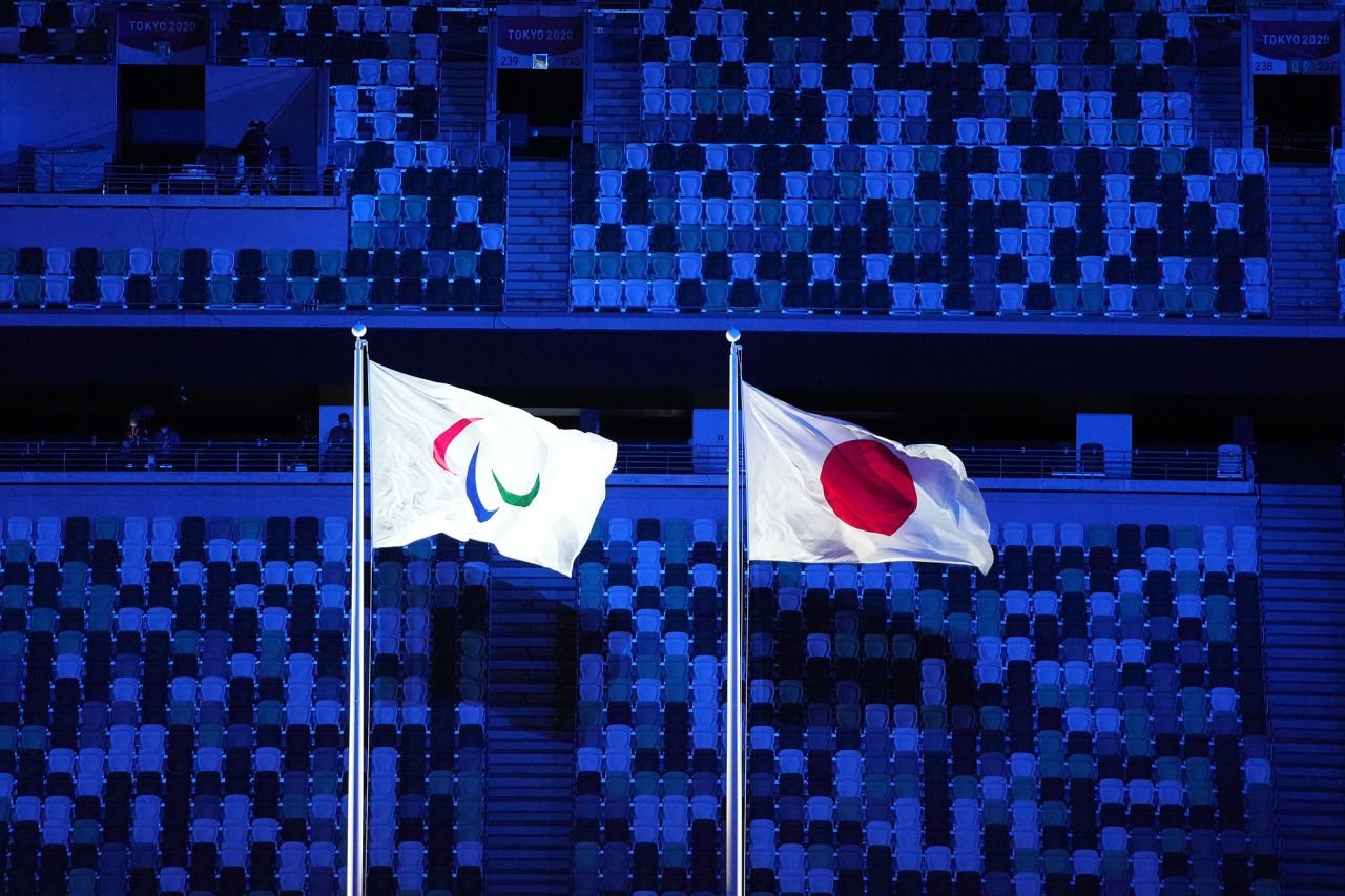 The Paralympic and Japanese flags are flown during the opening ceremony. Most of the stadium's seats were empty.