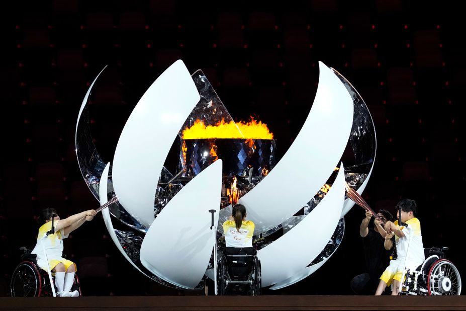 Morisaki, Kamiji and Uchida light the cauldron during the opening ceremony.