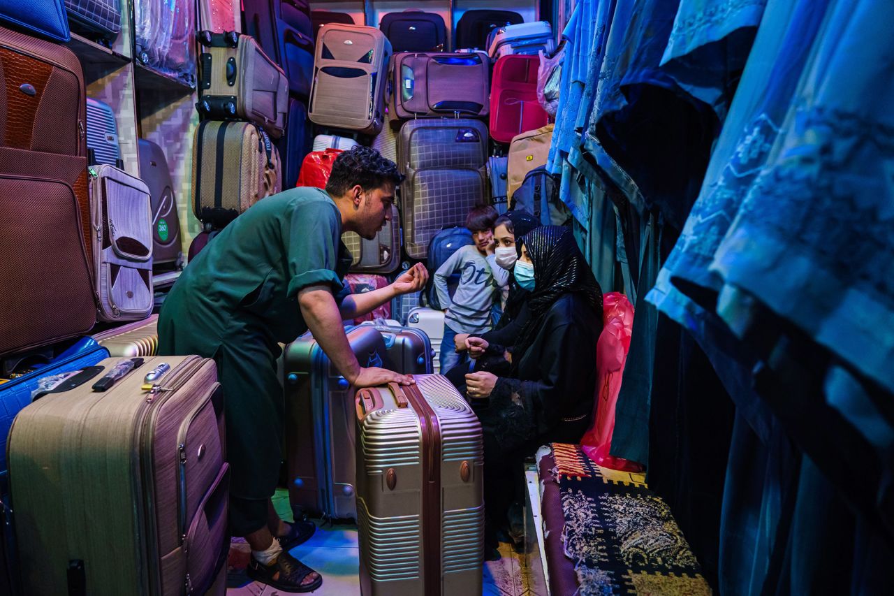 Amir Saib Zada negotiates with customers at his shop that sells luggage and burqas in Kabul's Lycee Maryam Bazaar on August 22.