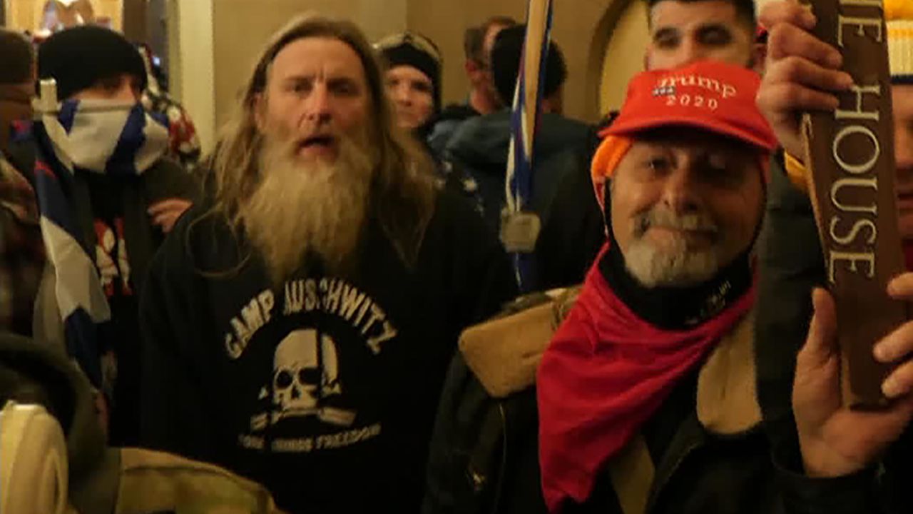 Robert Keith Packer, left, was seen at the Capitol Hill riot and insurrection wearing a sweatshirt with the words, "Camp Auschwitz."