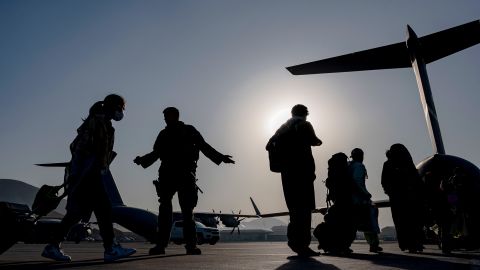 US Air Force airmen guide evacuees aboard a US Air Force C-17 Globemaster III at Hamid Karzai International Airport in Kabul, Afghanistan on Tuesday, August 24, 2021.