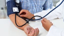 Doctor checking old man blood pressure. Health care background