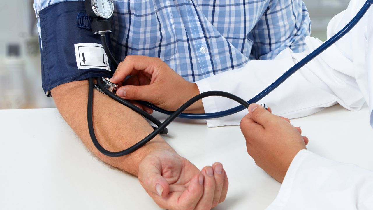 Doctor checking old man blood pressure. Health care background
