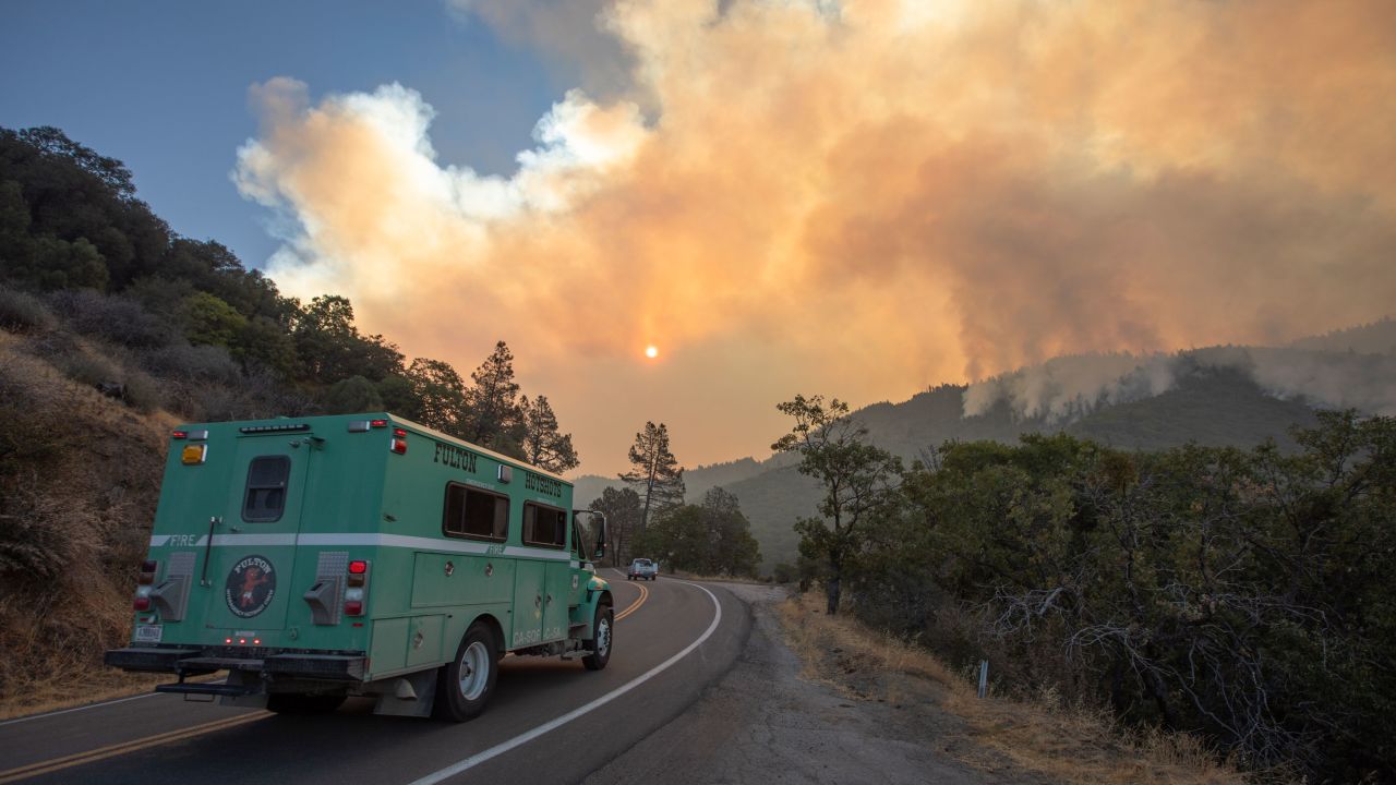 The Fulton Hotshots firefighting crew make their way to the French Fire as the plume rises in the early morning on August 24, 2021 near Wofford Heights, California. 