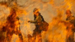 Arroyo Grande Hotshots firefighters are seen behind the flames of a backfire they are setting to battle the French Fire on August 24, 2021 near Wofford Heights, California. 