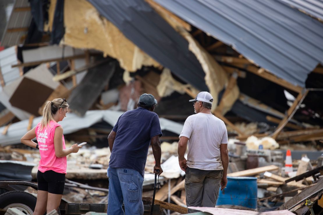 People watch cleanup efforts Monday after buildings were destroyed by flooding in Waverly, Tennessee. 