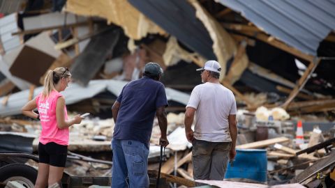 People watch cleanup efforts Monday after buildings were destroyed by flooding in Waverly, Tennessee.