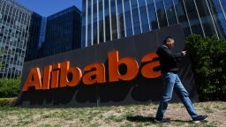 A man walks past an Alibaba sign outside the company's office in Beijing on April 13, 2021. 