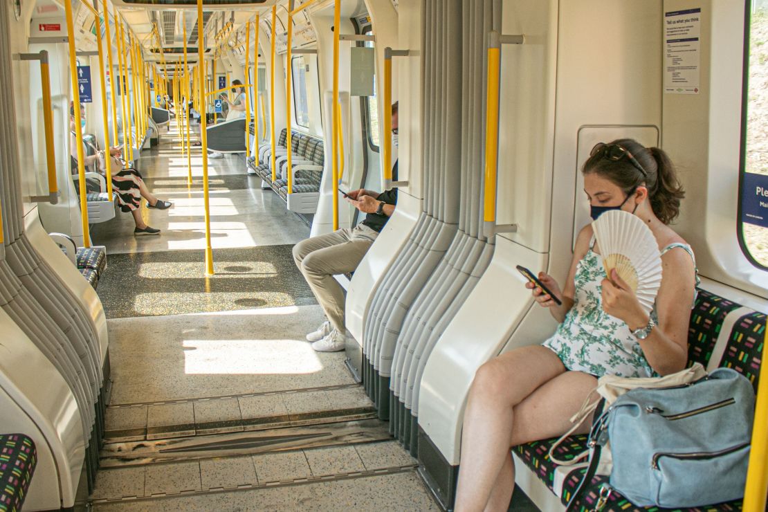 A passenger on the London Underground attempts to stay cool during a heat wave in August 2020.