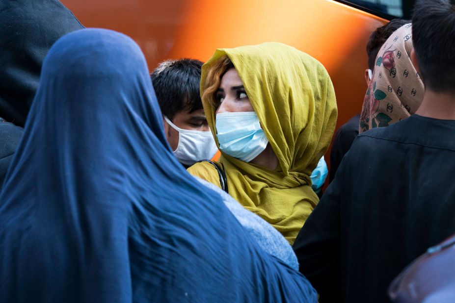 Families who fled Kabul, Afghanistan, wait to board a bus in Chantilly, Virginia, after they arrived at Washington Dulles International Airport on August 25.