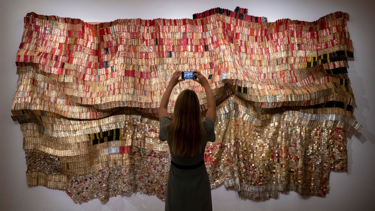 LONDON, ENGLAND - OCTOBER 02: A gallery technician takes a photo of work titled Vumedi Estimate: 800,000 - 1,200,000 GBP by artist El Anatsui from the 'Modern & Contemporary African Art' exhibition ahead of Sotheby's online auction taking place on 2nd to the 9th of October in London, England. (Photo by John Phillips/Getty Images for Sotheby's)