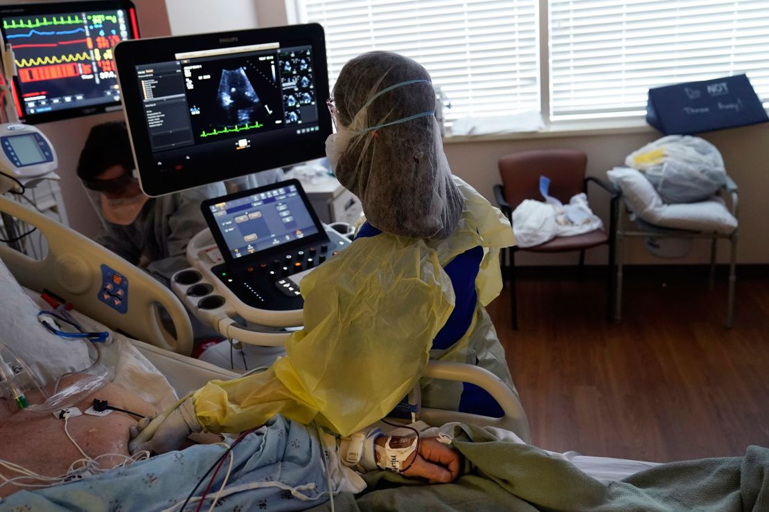 Tracy Brooks, an echocardiogram technician, takes readings from a critically ill Covid-19 patient in an intensive care unit at the Willis-Knighton Medical Center in Shreveport, Louisiana.