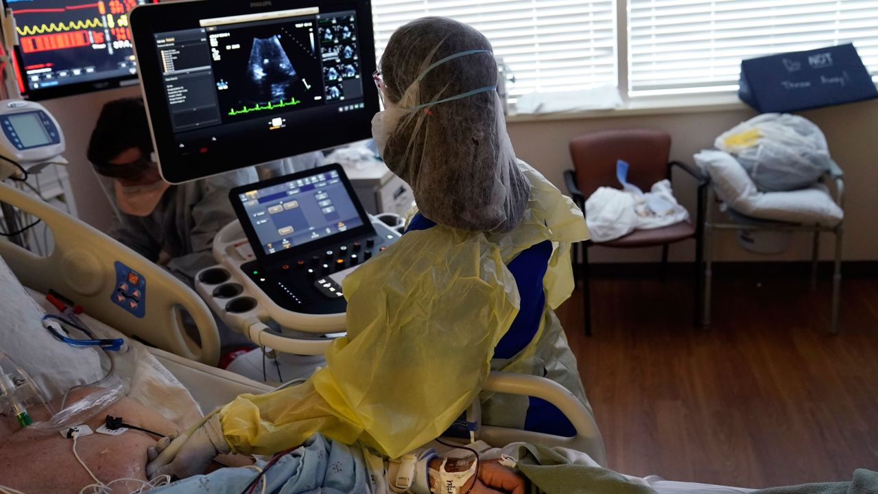 Tracy Brooks, an echocardiogram technician, takes readings from a critically ill Covid-19 patient in an intensive care unit at the Willis-Knighton Medical Center in Shreveport, Louisiana.