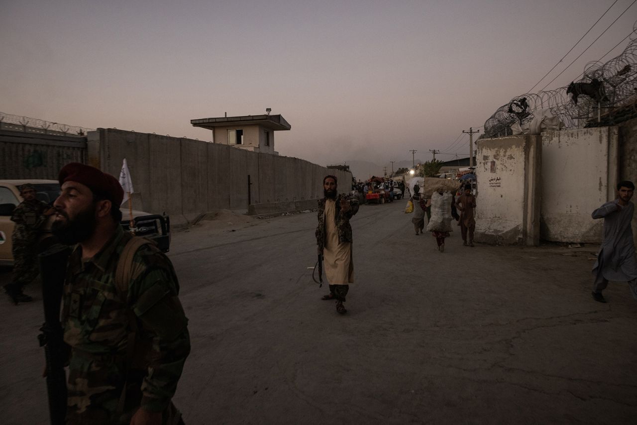 Taliban members guard a road near the airport after the bombing on Thursday.
