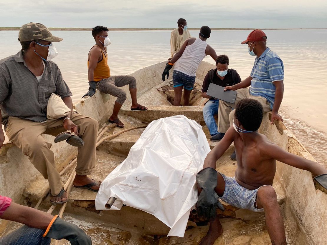 A body is draped in plastic sheeting after being recovered from the river bank by Wad El Hilou, Sudan.